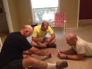 Don, Coop, and Ben Powers play cards in the empty old house. Photo by Shelley Powers